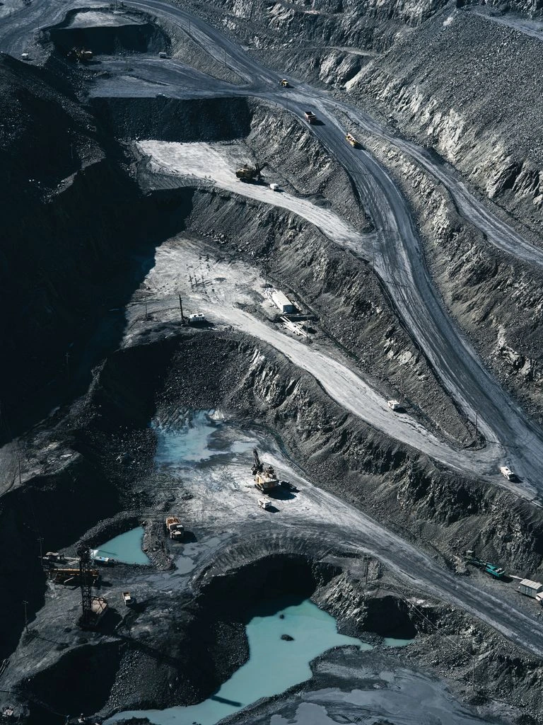 Aerial documentary photograph of an open-pit lithium mine at dusk in the Atacama region.